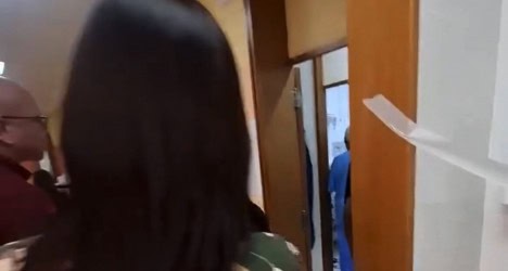 Homem entrando em sala com porta aberta.