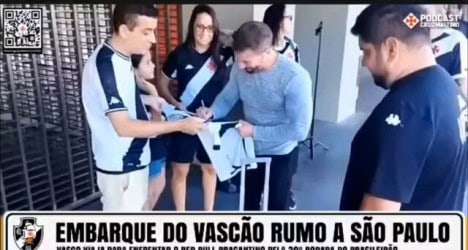 Jogadores do Vasco assinando camisa.