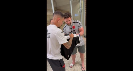 Atleta do Vasco assinando camisa.