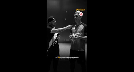 Homem entregando prêmio a jogador de futebol.