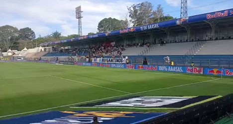 Estádio de futebol vazio com gramado bem cuidado.
