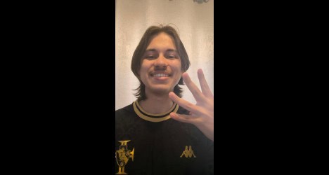 Jovem sorrindo com uniforme do Vasco.