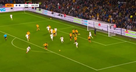 Jogadores em ação durante partida de futebol no campo.