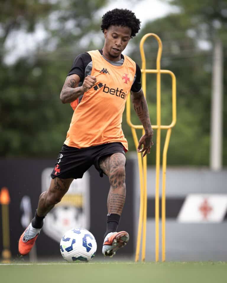 Goleiro treinando com bola durante treino no campo.