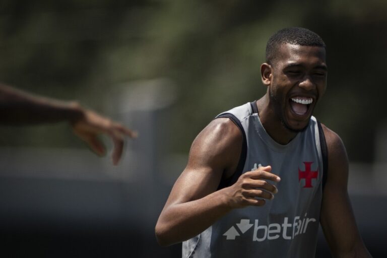 Jogador sorrindo, treino ao ar livre.