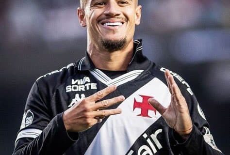 Jogador do Vasco sorrindo com uniforme preto e branco.