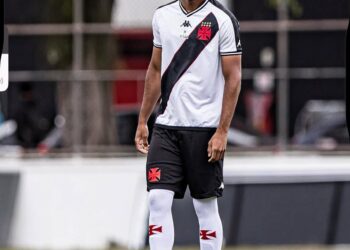 Vascaio com uniforme do Vasco, em campo de futebol.