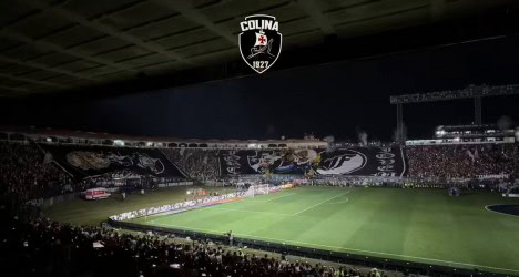 Estádio de futebol lotado à noite.