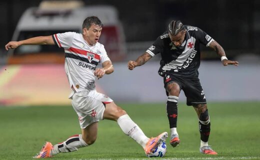 Jogador do São Paulo e adversário duelando pela bola em campo.