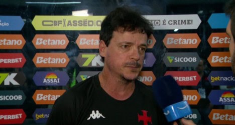 Homem em entrevista com microfone azul.