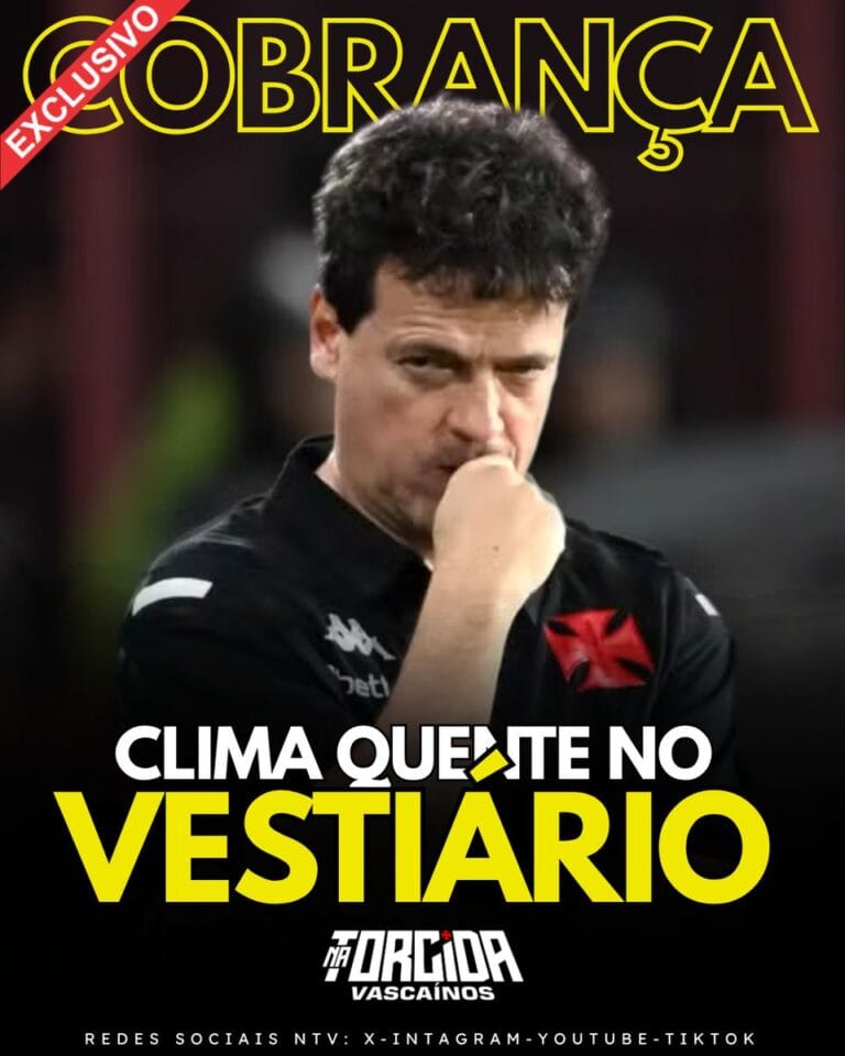 Vasco coach pensativo com uniforme preto, fundo escuro.