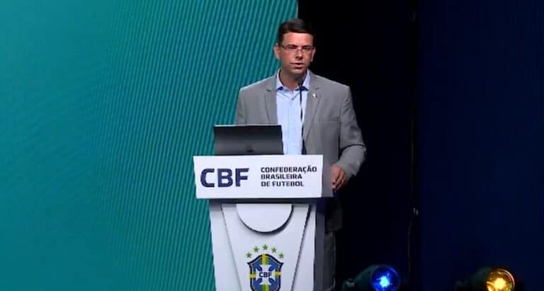 CBF, conferência de futebol, homem em palestra, palco com logo, apresentação esportiva.