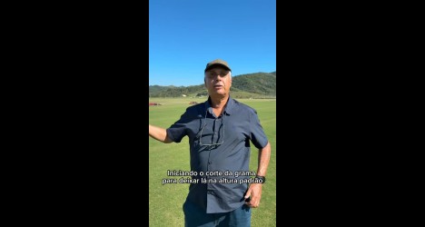 Homem segurando régua no campo.