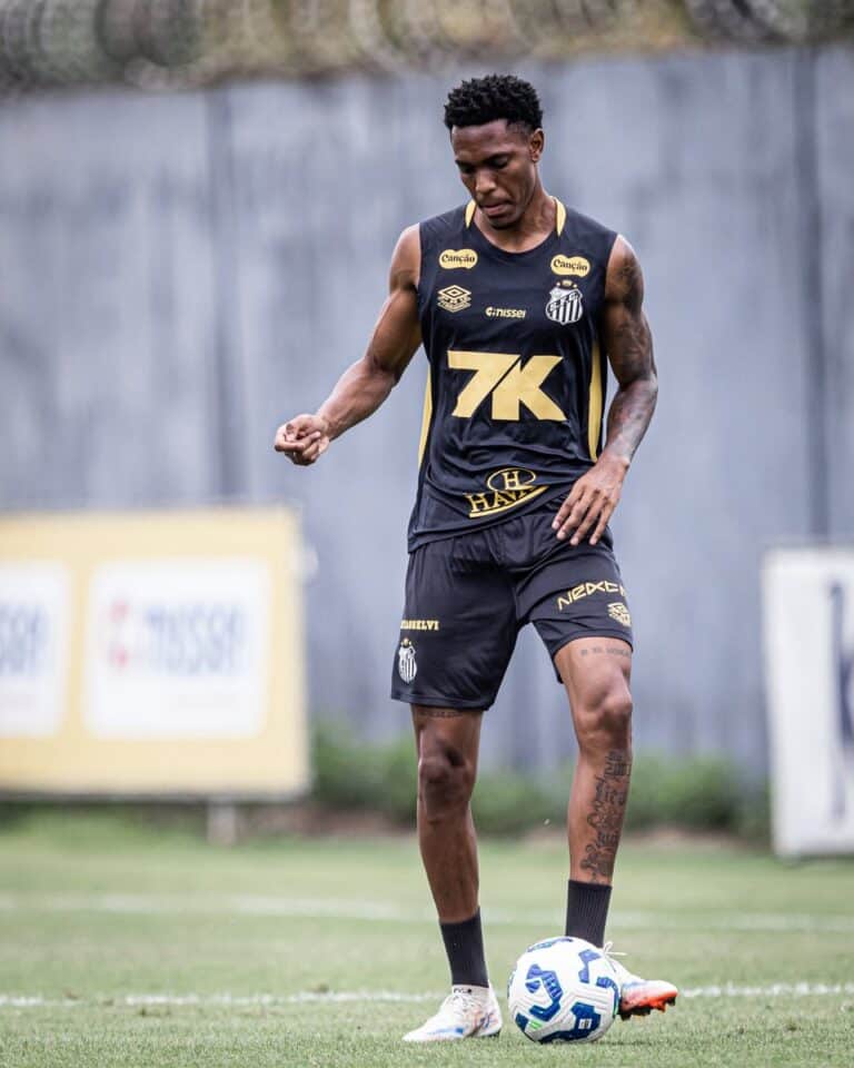 Jogador do Santos com bola nos pés em treino ao ar livre.