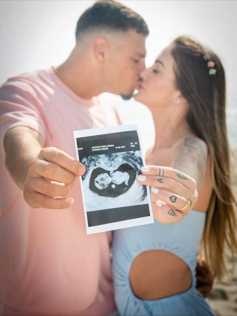 1. Gestante segurando ultrassom na praia.