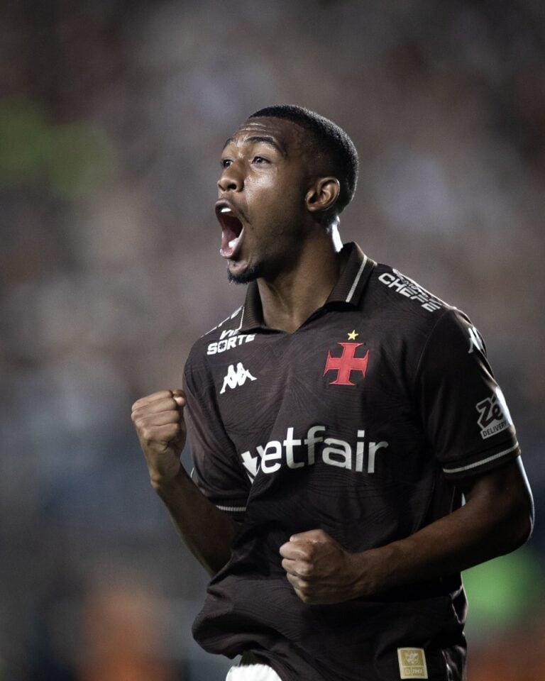 Jogador de futebol comemorando gol com expressão de alegria.