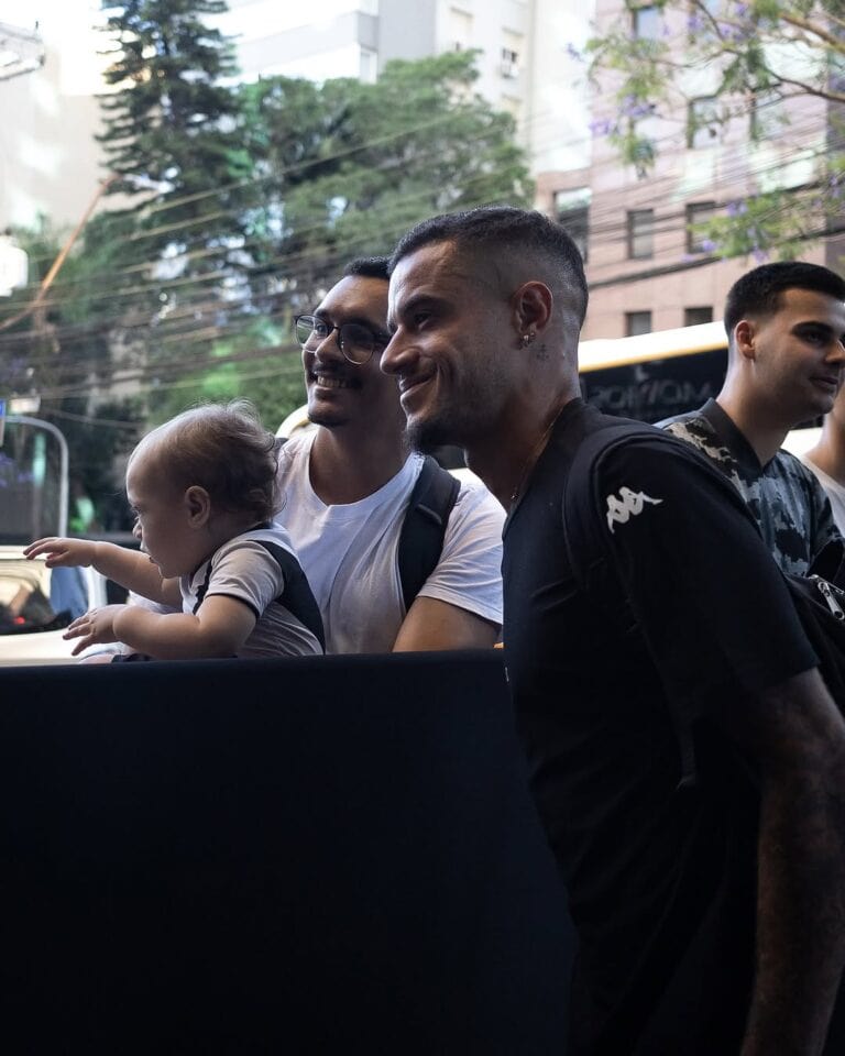 Vasco da Gama com torcedores e criança sorrindo em rua.