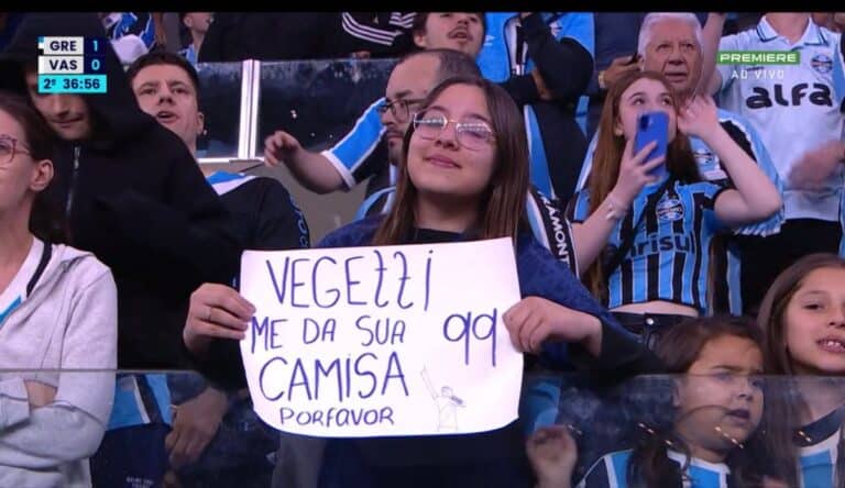 Vasca torcedor segurando cartaz no estádio.