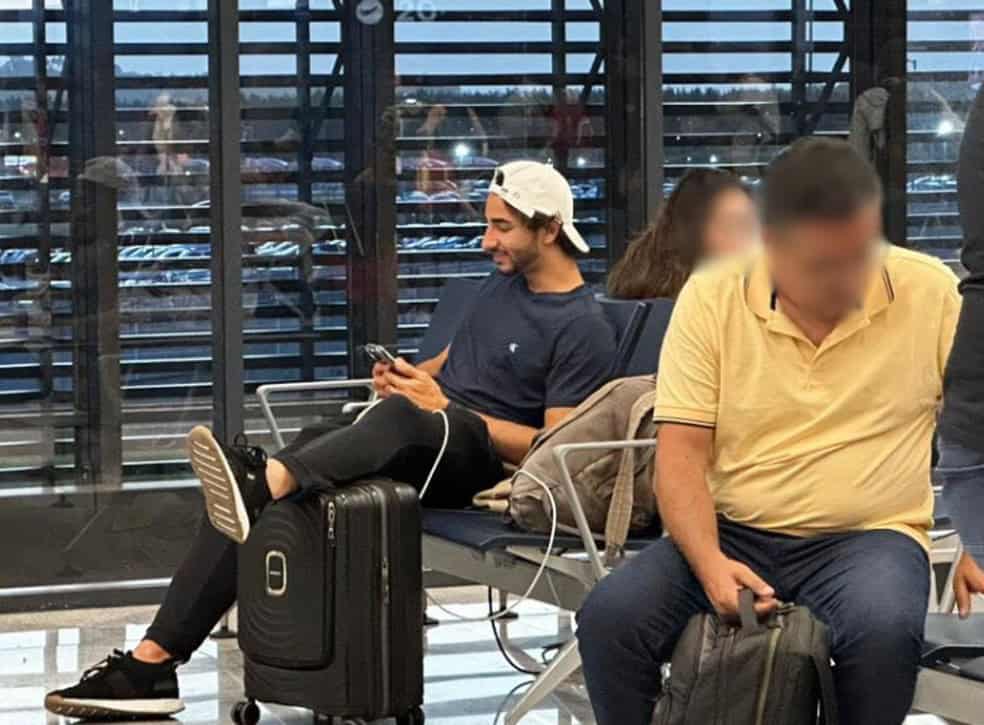 1. Jovem usando camiseta azul e boné branco.