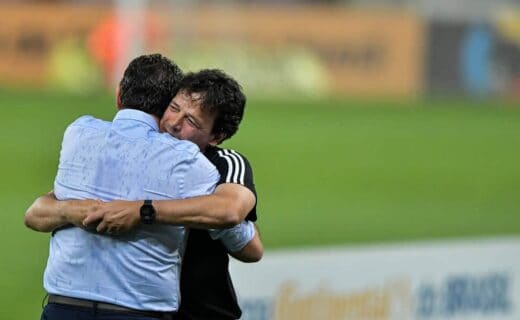1. Abraço entre dois homens no campo de futebol.