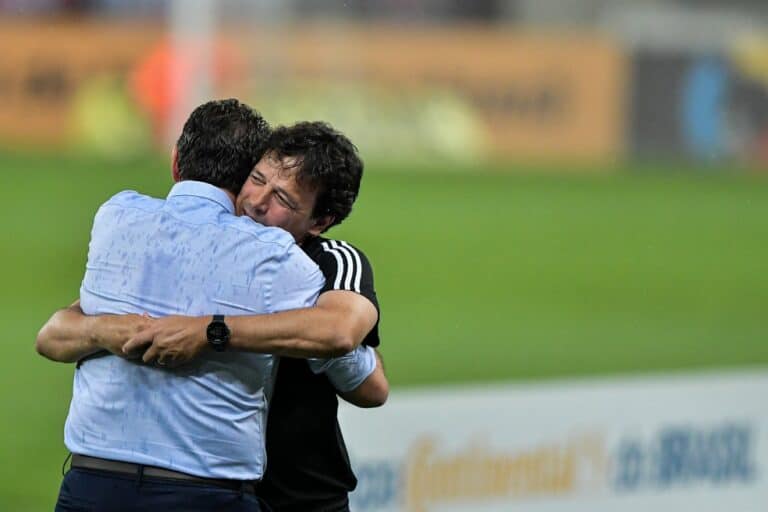 1. Abraço entre dois homens no campo de futebol.