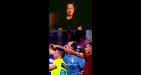 Homem com cabelo longo e barba, rosto sério.