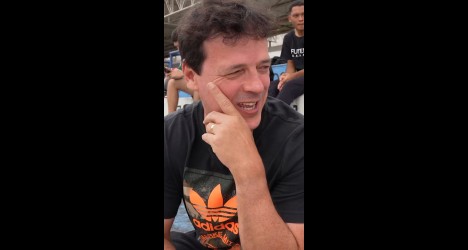 Homem sorridente com cabelo escuro.