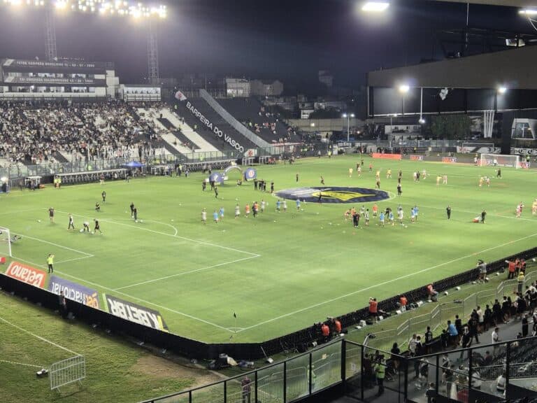 Jogadores e comissão técnica em atividade no campo de futebol.