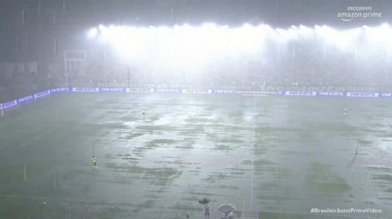 Campo de futebol alagado pela chuva forte.