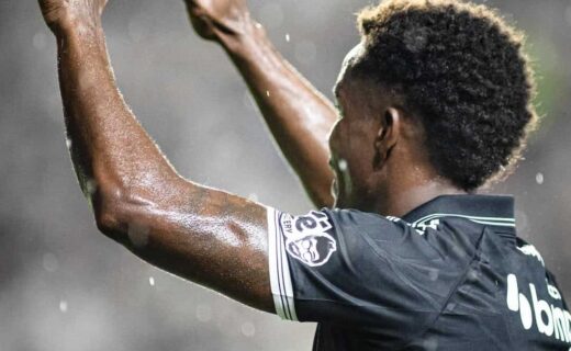 Jogador do Vasco em ação, celebrando uma jogada, com destaque para o uniforme do time.