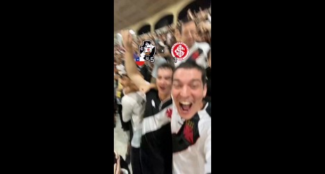 Grupo de torcedores sorrindo e comemorando com camisetas do Vasco, em clima de celebração e paixão pelo clube em um evento.