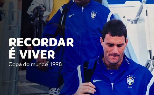 Jogadores do Vasco em chegada ao aeroporto, trajando jaquetas azul com o escudo do clube, carregando malas e mochila, em meio a viagem para a Copa do Mundo de 1998.
