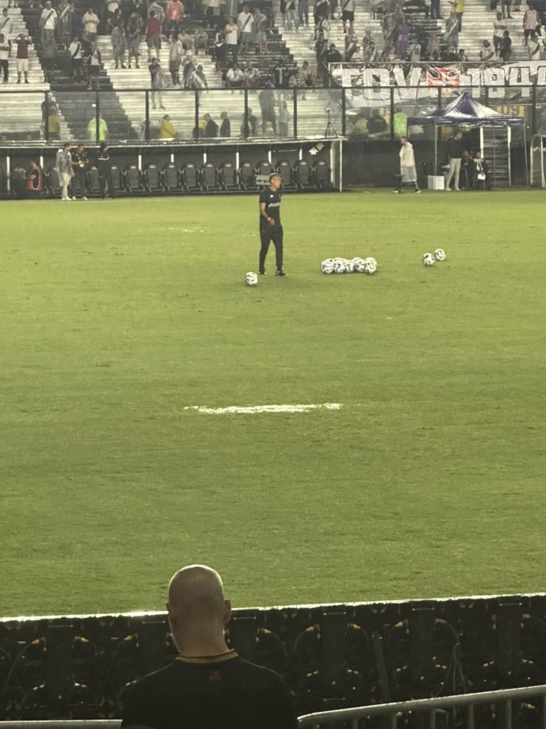 Jogador treinando com bolas no gramado.