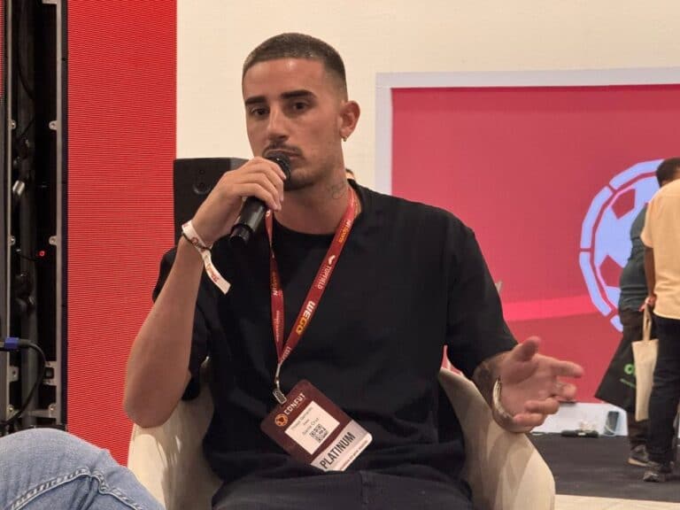 Homem falando ao microfone em evento.