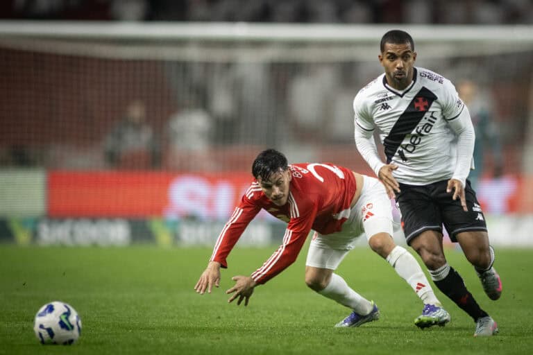 Jogadores de futebol competindo por posse de bola no campo.