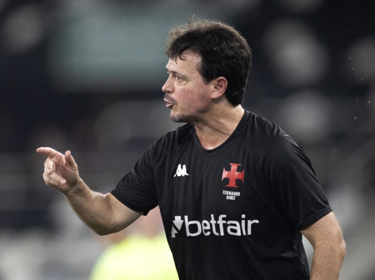 Torcedor do Vasco usando uniforme preto, durante jogo de futebol, focado na partida.