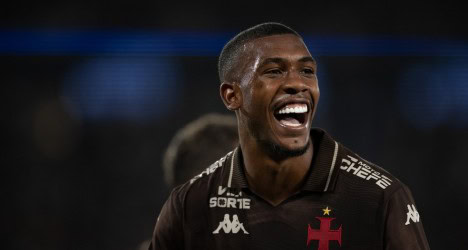Jogador do Vasco sorrindo com uniforme preto.