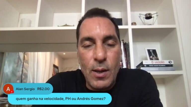 Homem falando em vídeo, fundo com estante e livros.