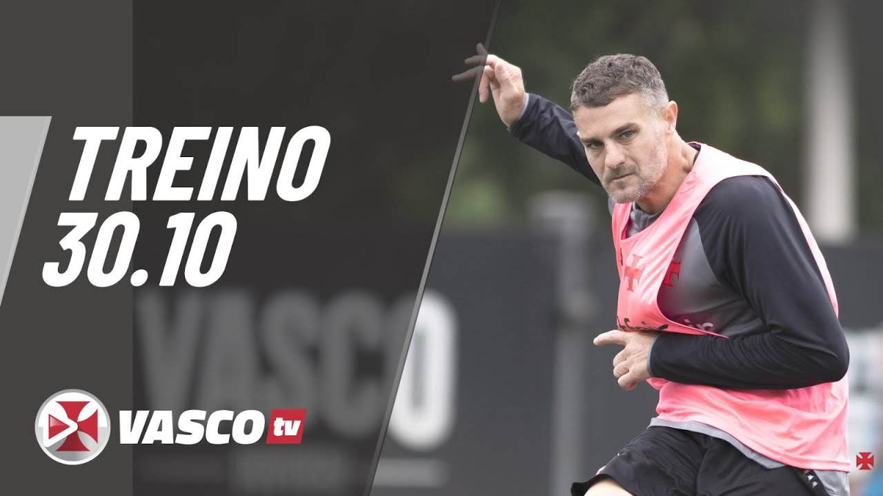 Futebolista treinando com colete rosa em campo.