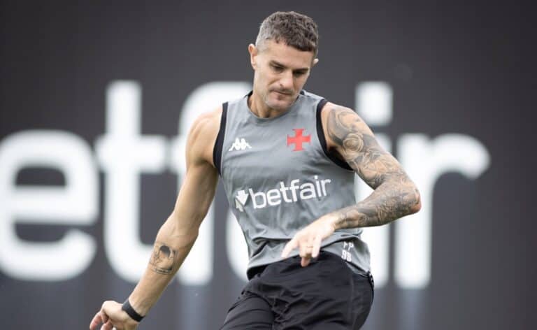 Jogador vestindo camisa cinza do Vasco, treina com foco e concentração.